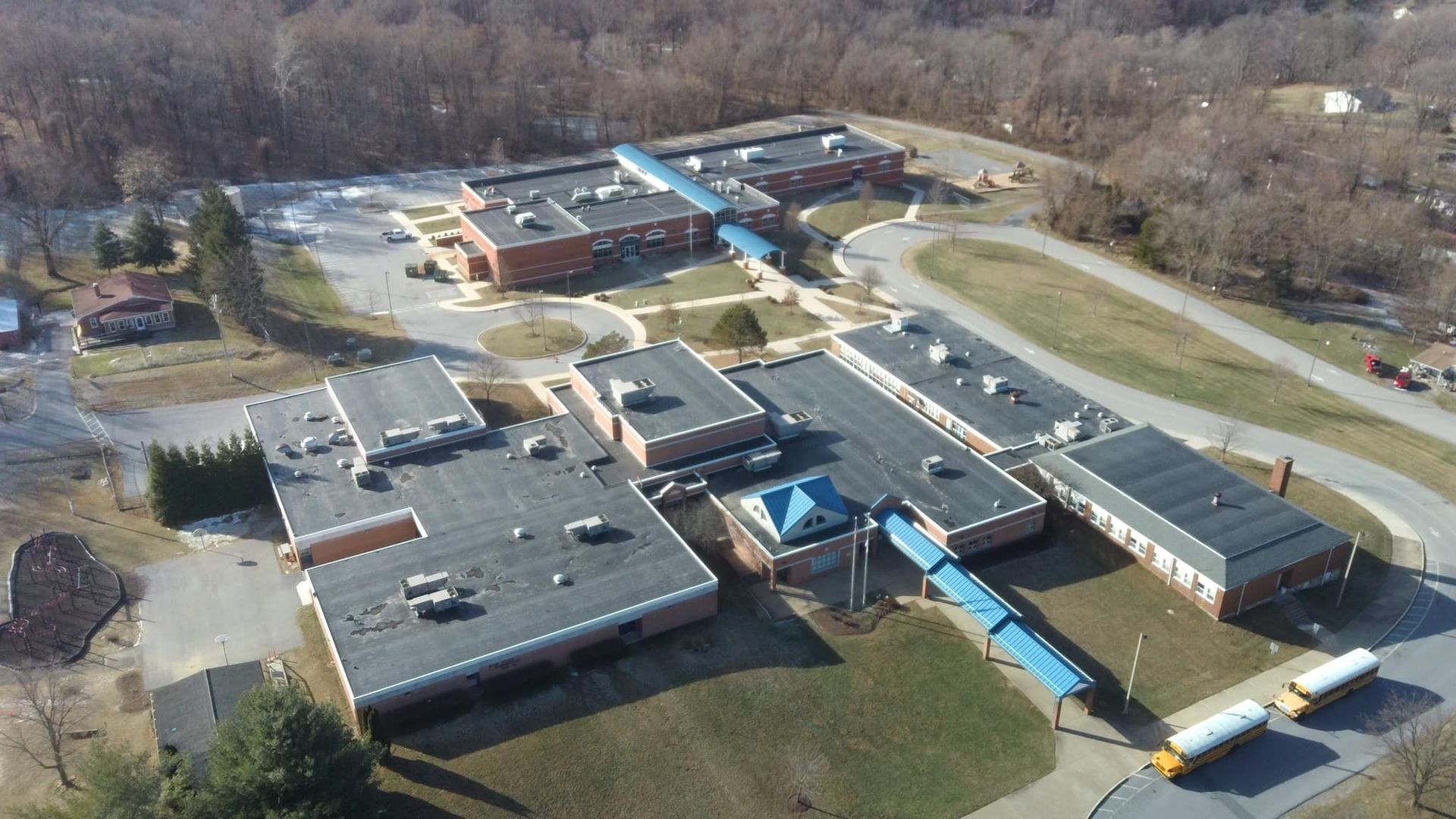 Aerial view of a school campus near Martinsburg WV showing large flat membrane commercial roof sections with rooftop HVAC units